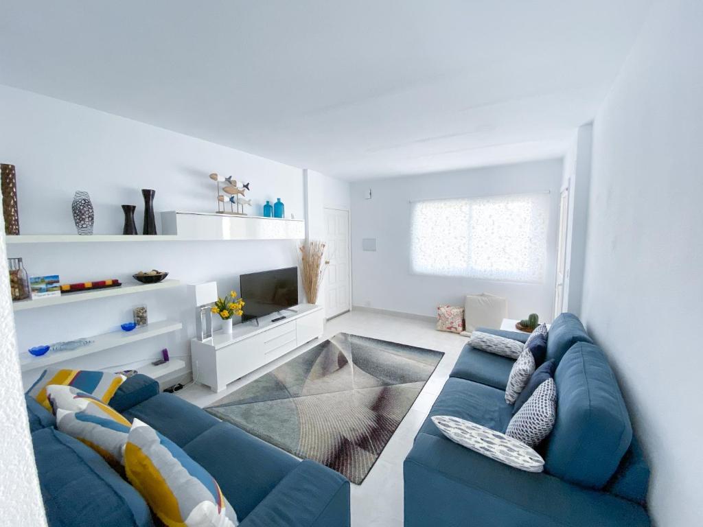 a living room with a blue couch and a tv at Bellaluz 18.15, La Manga Club Resort in Atamaría