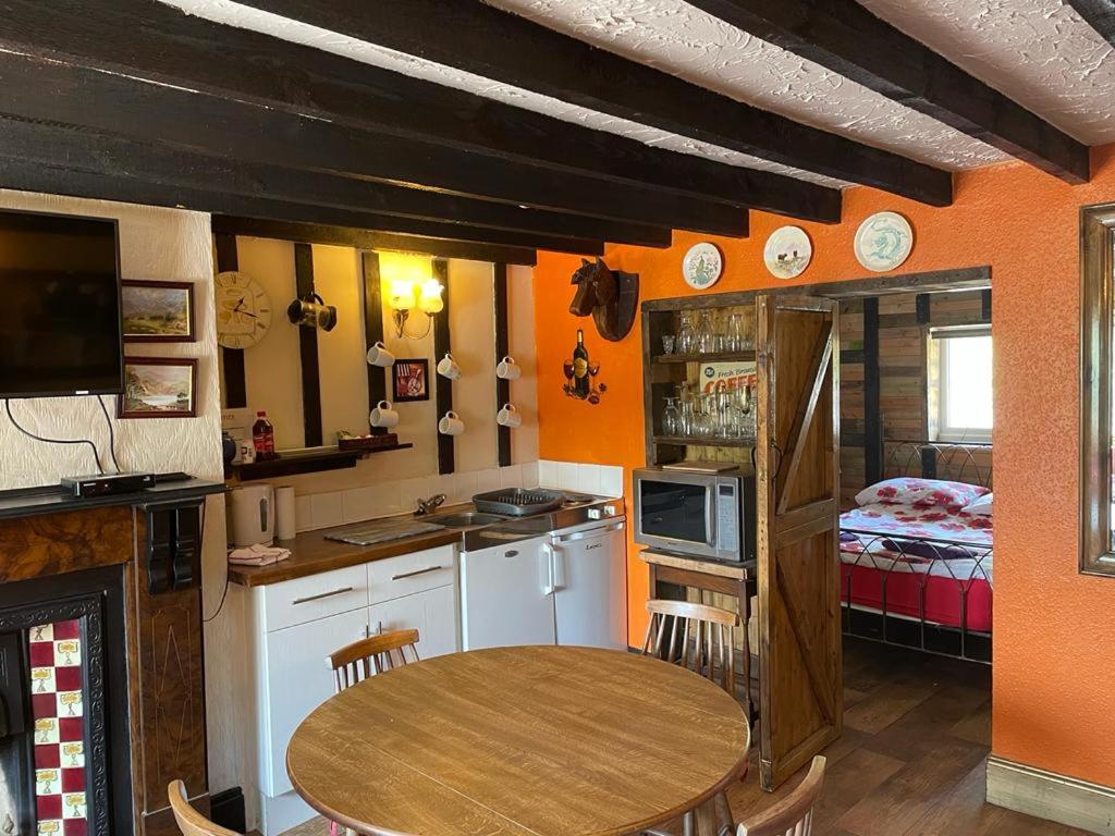 uma cozinha com uma mesa e um quarto com uma cama em Yarm cottages byre/paddock em Kirk Leavington