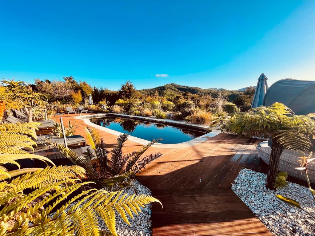 una piscina en un jardín con palmeras en Kaiteriteri Ridge Holiday Estate, en Kaiteriteri