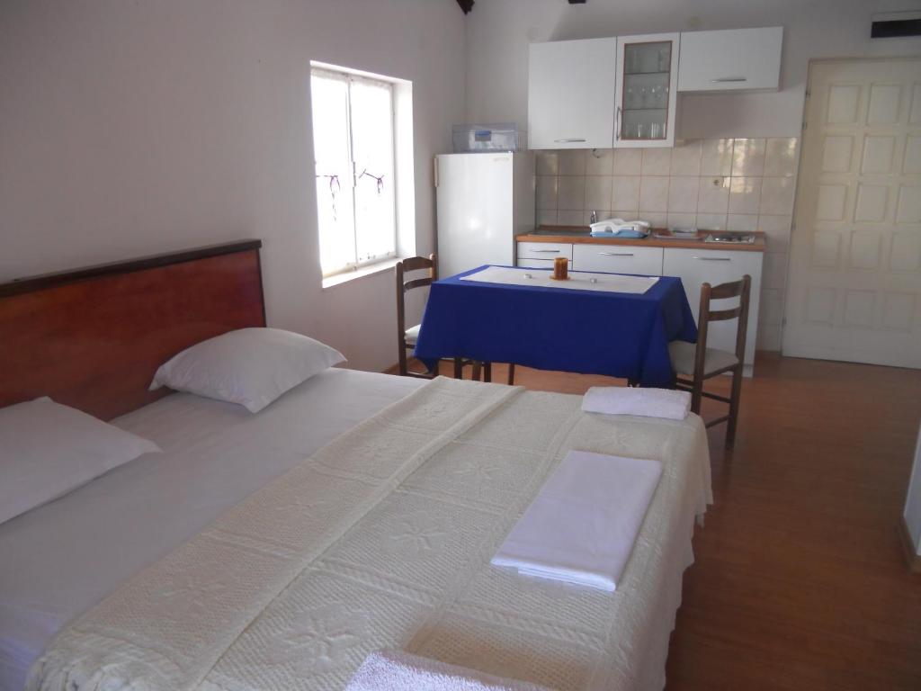 1 dormitorio con cama, mesa y cocina en Apartments Ivanka Bilo, en Primošten