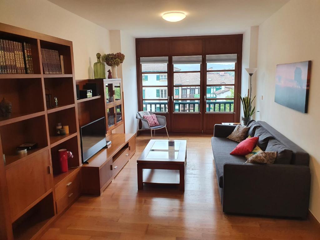 uma sala de estar com um sofá e uma mesa de centro em Luminoso piso con terraza y aparcamiento ESS01636 em Hondarribia