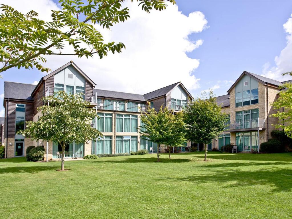 an exterior view of a building with trees in the yard at Apartment 2 in South Cerney