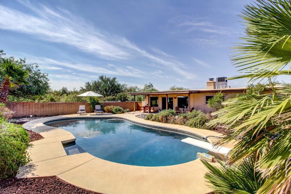 a swimming pool in a yard with a house at Stylish Tucson Home with Patio and Private Pool! in Tucson