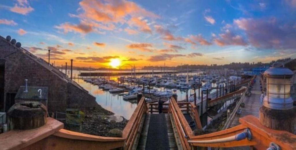 una puesta de sol sobre un puerto deportivo con barcos en el agua en Embarcadero Resort en Newport