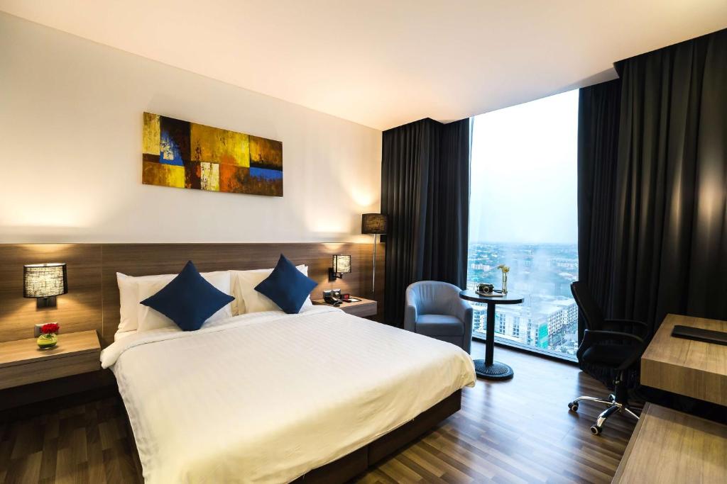 een hotelkamer met een bed en een bureau bij Best Western Plus Wanda Grand Hotel in Nonthaburi