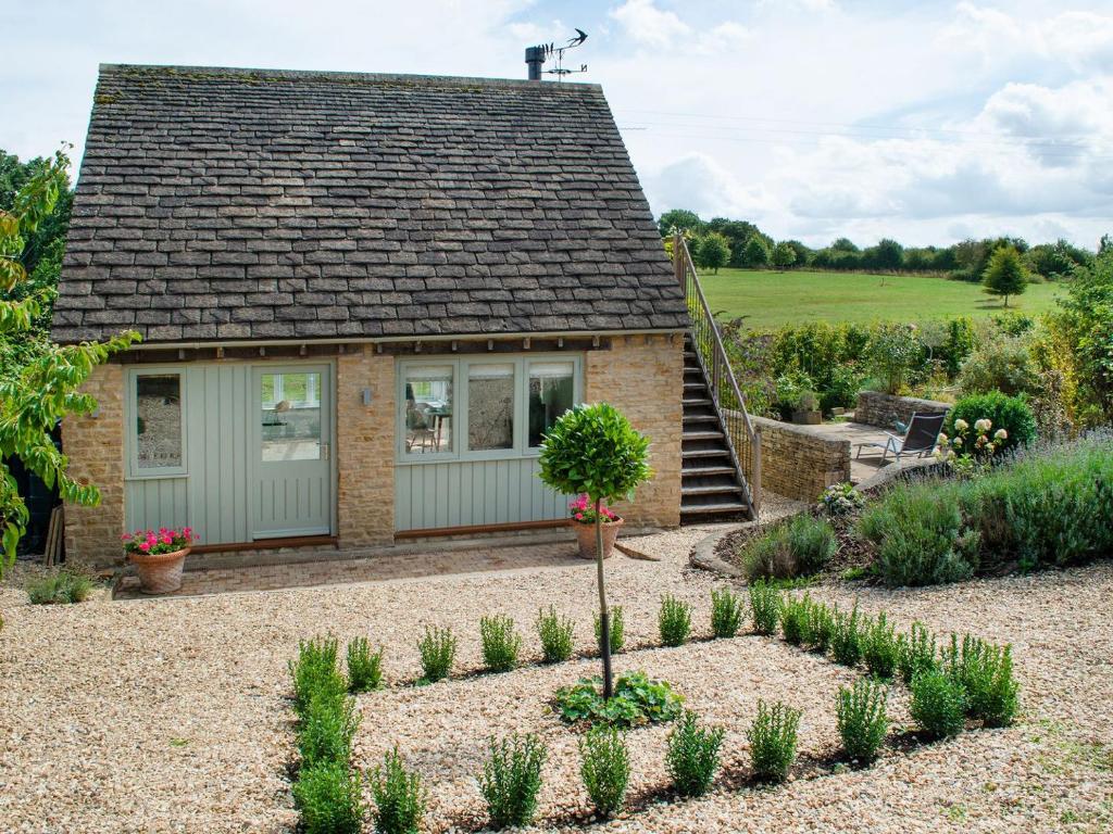 un cottage avec un jardin en face dans l'établissement Swallows Nest, à Bibury