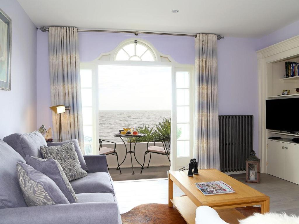 a living room with a couch and a view of the ocean at Seashore Apartment in Sandgate