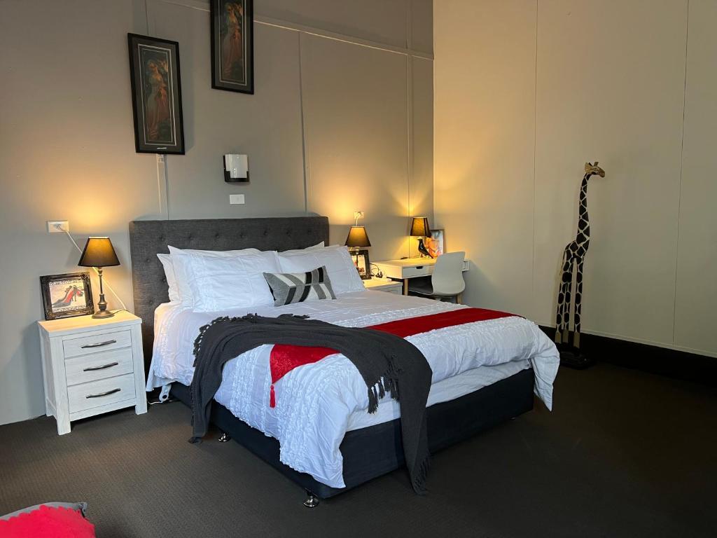 1 dormitorio con 1 cama grande y 2 mesitas de noche en Longhorn Ranch Apartments, en Orbost