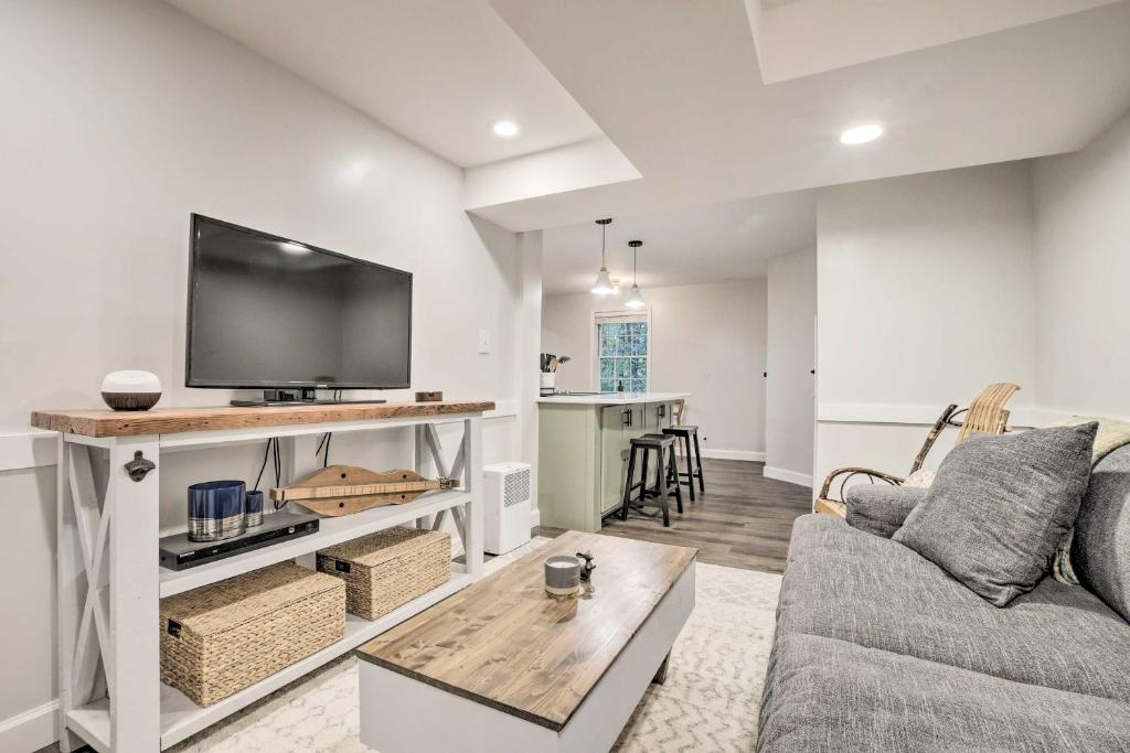 a living room with a couch and a flat screen tv at Dog-Friendly Raleigh Apartment about 5 Mi to Downtown! in Raleigh