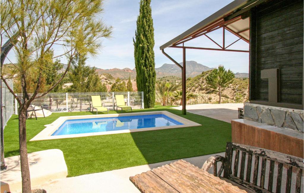 een achtertuin met een zwembad en groen gras bij Cozy Home In El Rellano- Murcia With Kitchen in Las Casicas