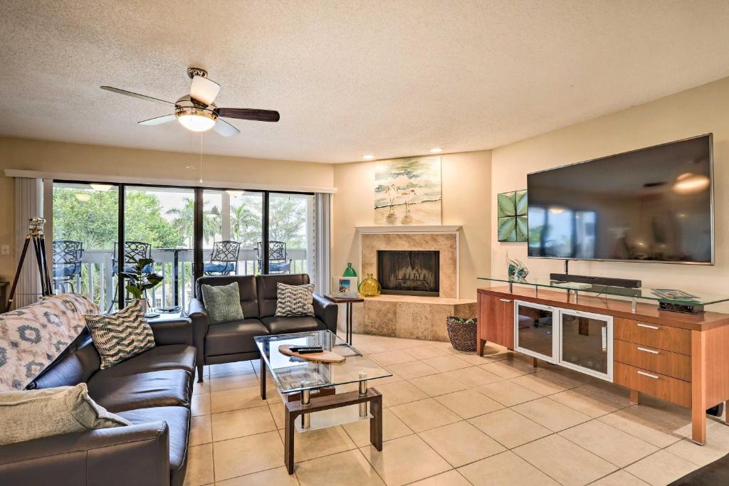 a living room with a couch and a large tv at Sea La Vie Sunny Indian Rocks Beach Condo! in Clearwater Beach