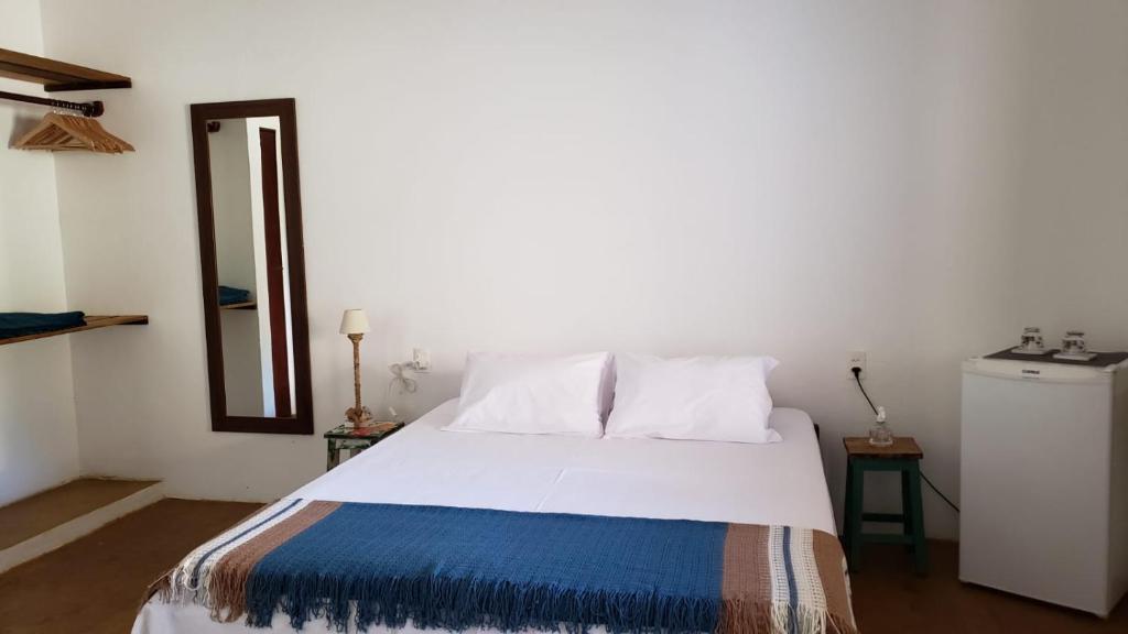 a bedroom with a large white bed and a mirror at Pousada Yemanjá Cunhaú in Barra do Cunhau