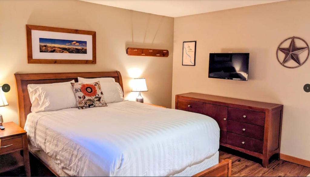 a bedroom with a bed and a tv on the wall at Driftin' Cabanas in Chelan