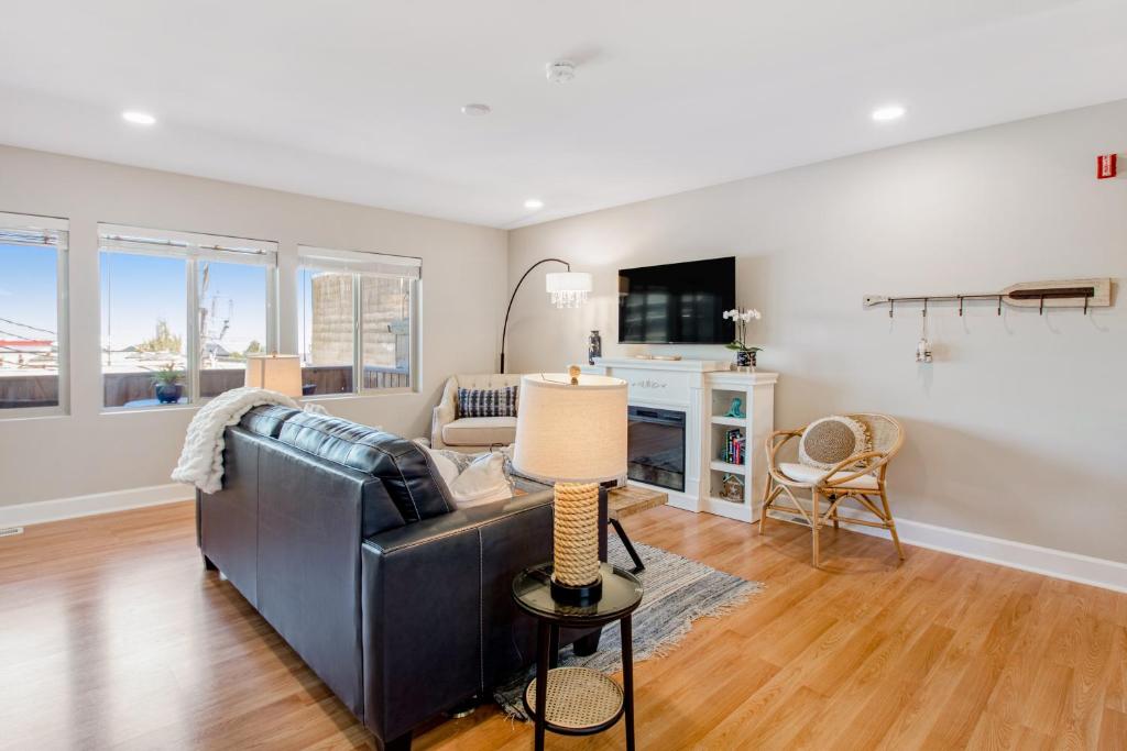 a living room with a black leather couch and a table at Port Angeles Water View Loft in Port Angeles