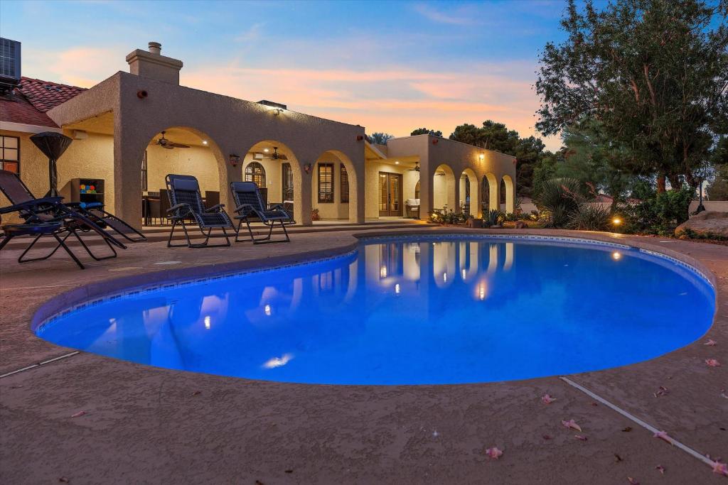 a large blue swimming pool in front of a house at Ranch style villa with pool and spa in Las Vegas