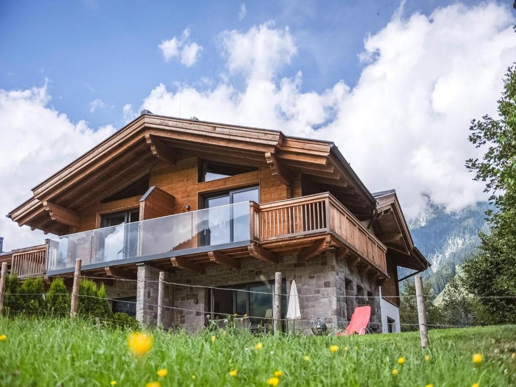 a log house with a deck on a hill at Chalet Anna XL Leogang in Leogang