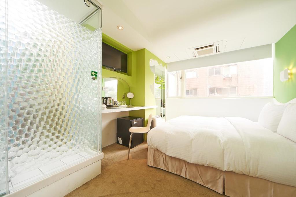 a bedroom with a bed and a glass shower at Forever Inn in Taipei