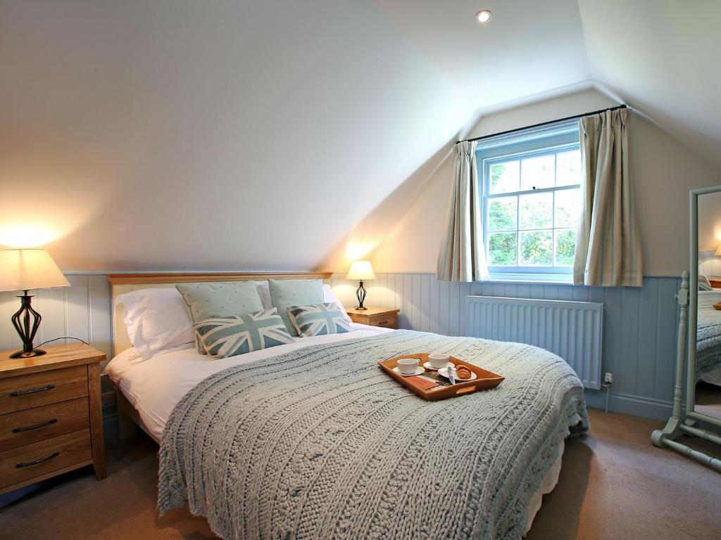 a bedroom with a large bed with a tray on it at Sawmill Cottage in Royal Tunbridge Wells