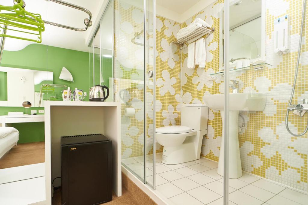 a bathroom with a toilet and a glass shower at Forever Inn in Taipei