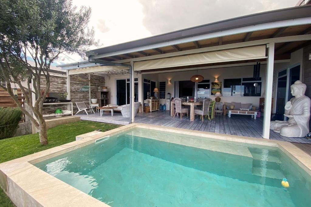 a swimming pool in the backyard of a house at Villa WABISABI cosy home in Punaauia