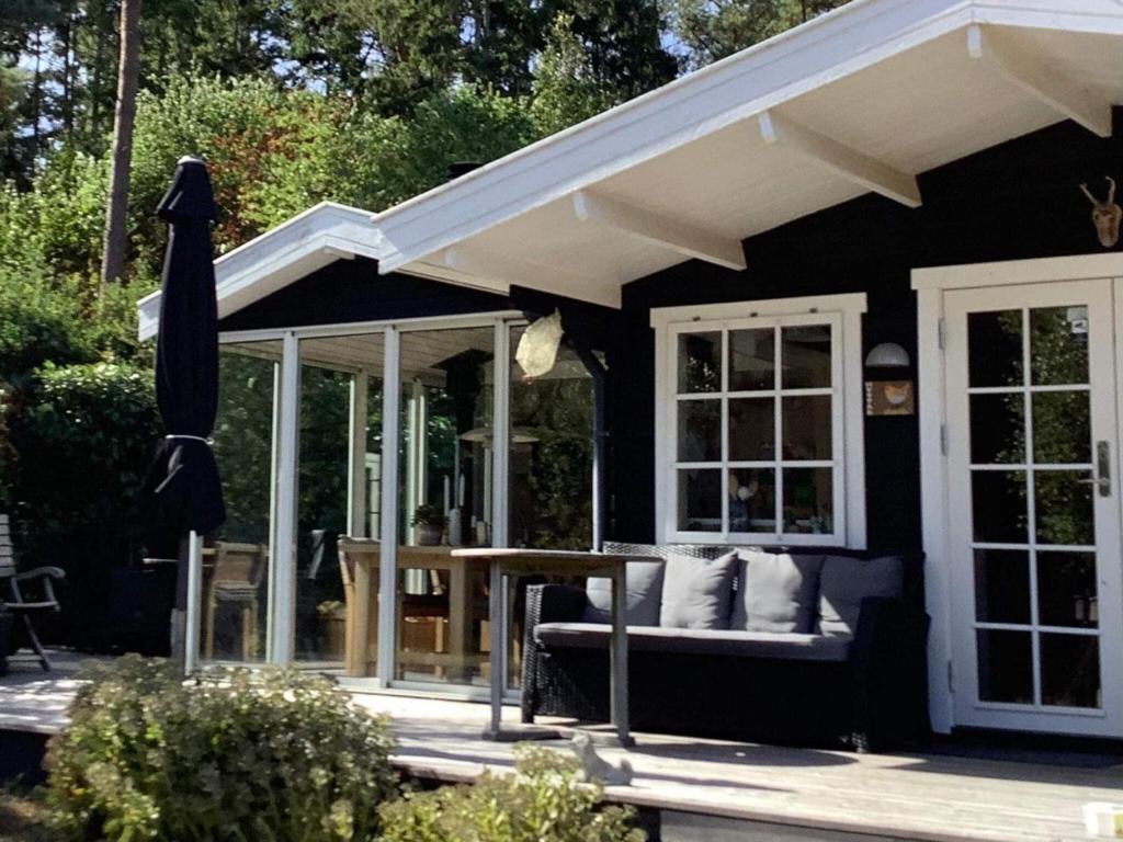een patio met een bank, een tafel en een parasol bij Holiday home Hasle VII in Hasle