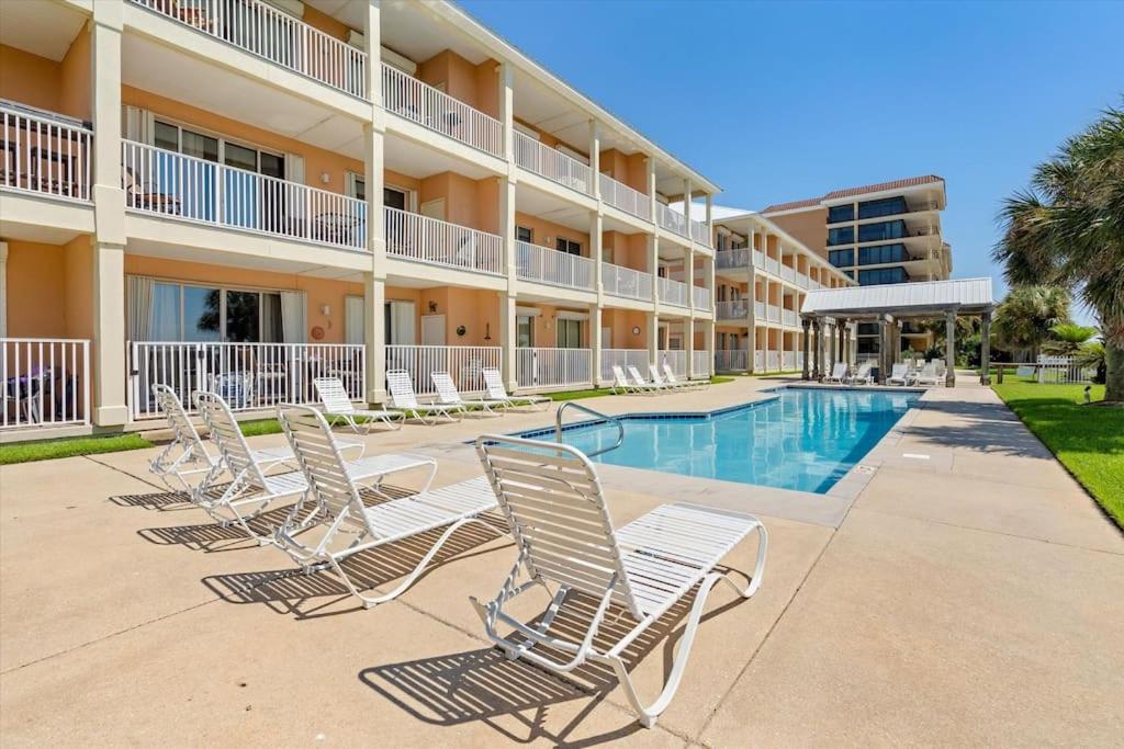 a row of chairs in front of a hotel with a swimming pool at The Pelican Place - Amazing Views, Top Floor Condo in Dauphin Island