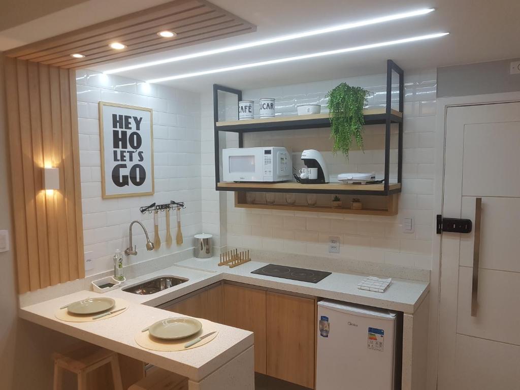 Hotel ESPETACULAR APARTAMENTO NO LEBLON, a kitchen with a refrigerator and a counter top at ESPETACULAR APARTAMENTO NO LEBLON in Rio de Janeiro