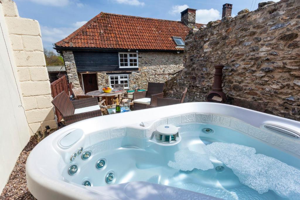 a jacuzzi tub sitting on top of a building at Southcott Farm Cottage in Honiton