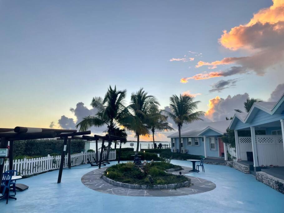 a patio with tables and chairs and palm trees at Beautiful Villa just steps away from the beach! in Georgetown