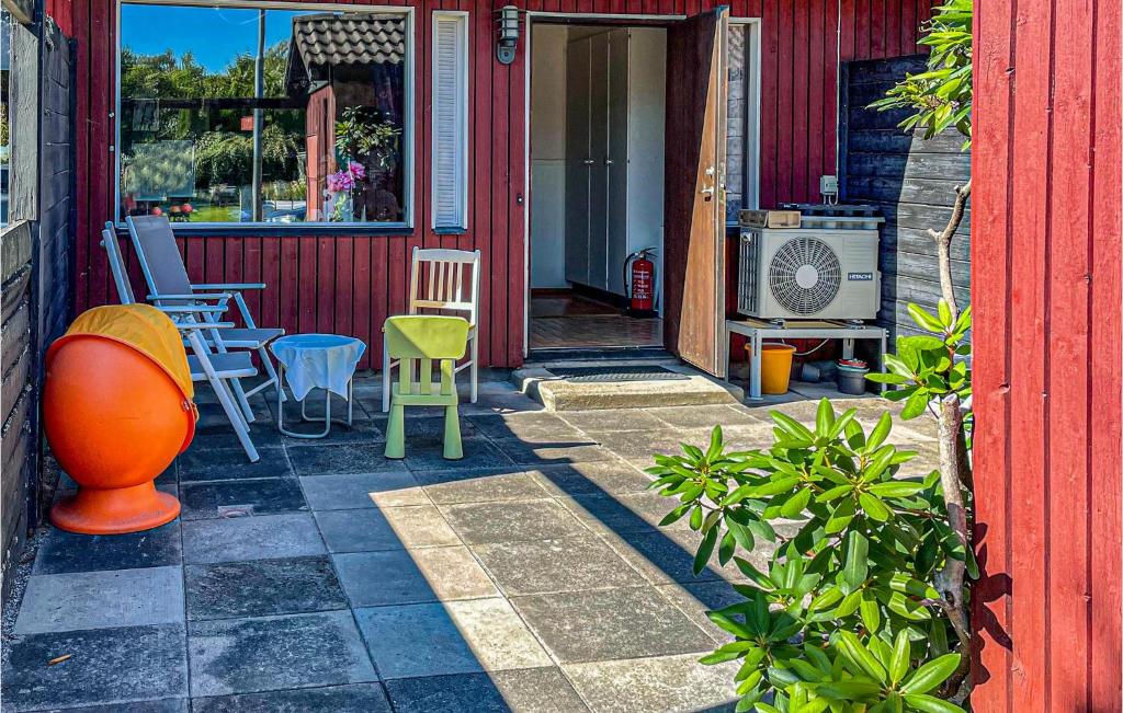 a red house with a patio with chairs and a heater at 2 Bedroom Cozy Home In Virsbo in Virsbo Bruk