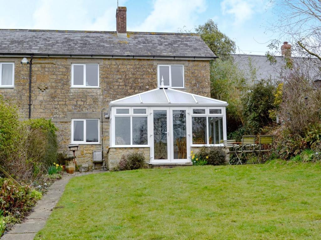 an extension to a house with a conservatory at Regina Cottage in Bradpole