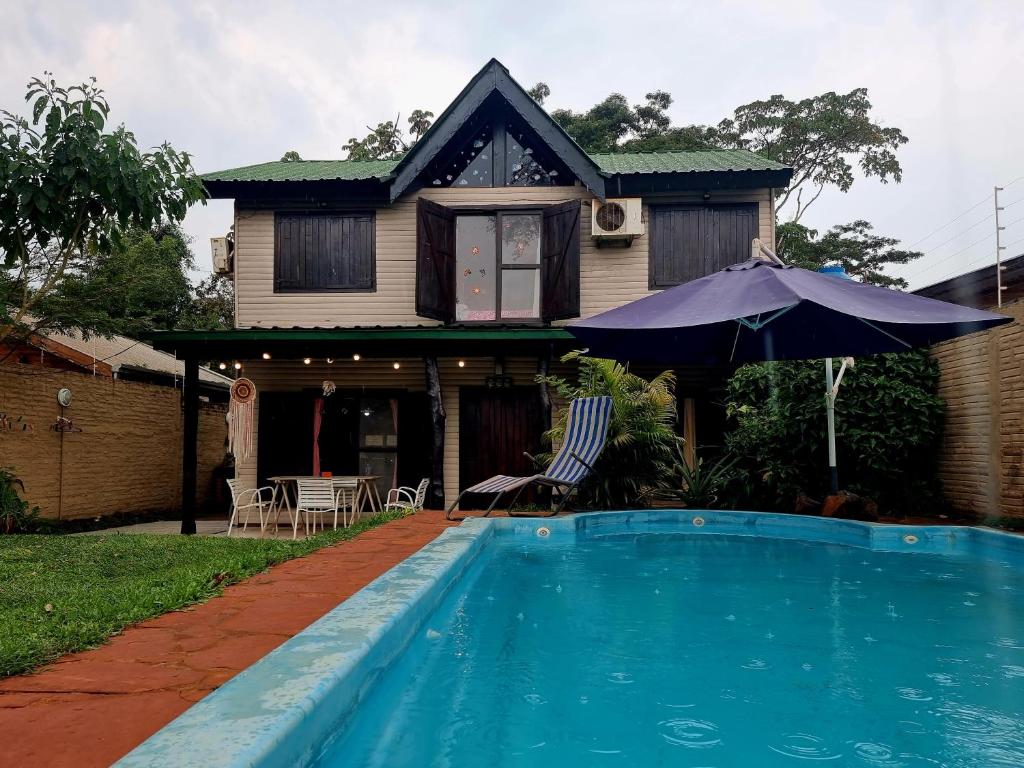 uma casa com piscina em frente a uma casa em La Morada del Sol em Puerto Iguazú