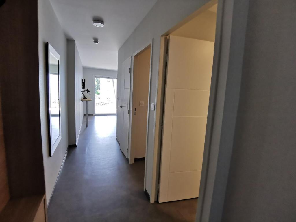un couloir d'un appartement avec des murs et des portes blancs dans l'établissement Appartement La Tranche-sur-Mer, 2 pièces, 4 personnes - FR-1-194-228, à La Tranche-sur-Mer