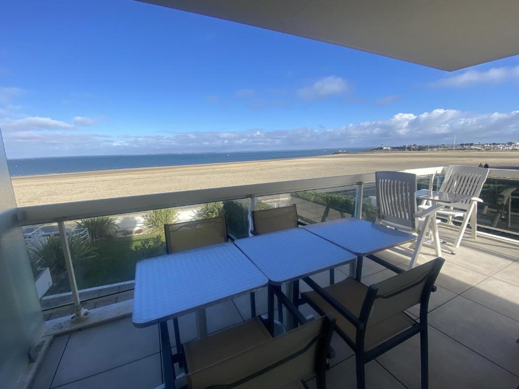 - une table bleue et des chaises sur un balcon donnant sur la plage dans l'établissement T3 à Arcachon avec vue mer, parking privé et Wi-Fi - FR-1-374-180, à Arcachon