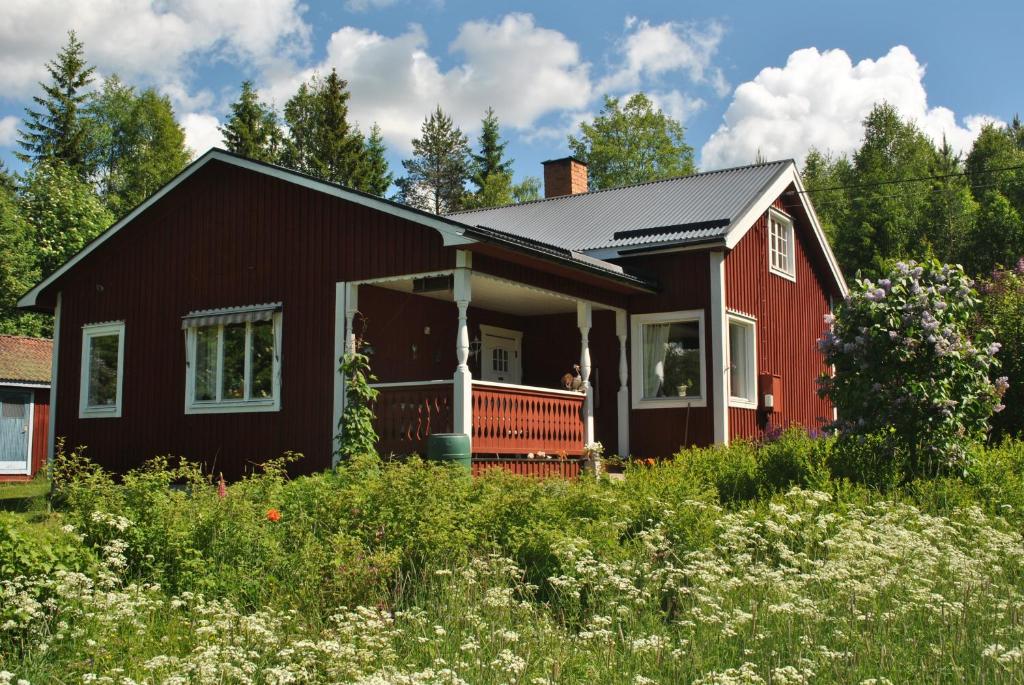 a red house with a red porch at Orsastuguthyrning-Oljonsbyn in Orsa