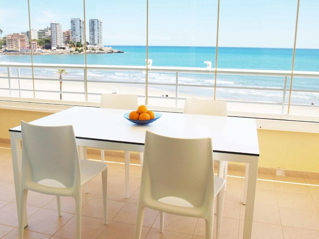 ein Esszimmer mit Tisch und Stühlen und dem Meer in der Unterkunft ApartUP Spectacular Beach View in Oropesa del Mar