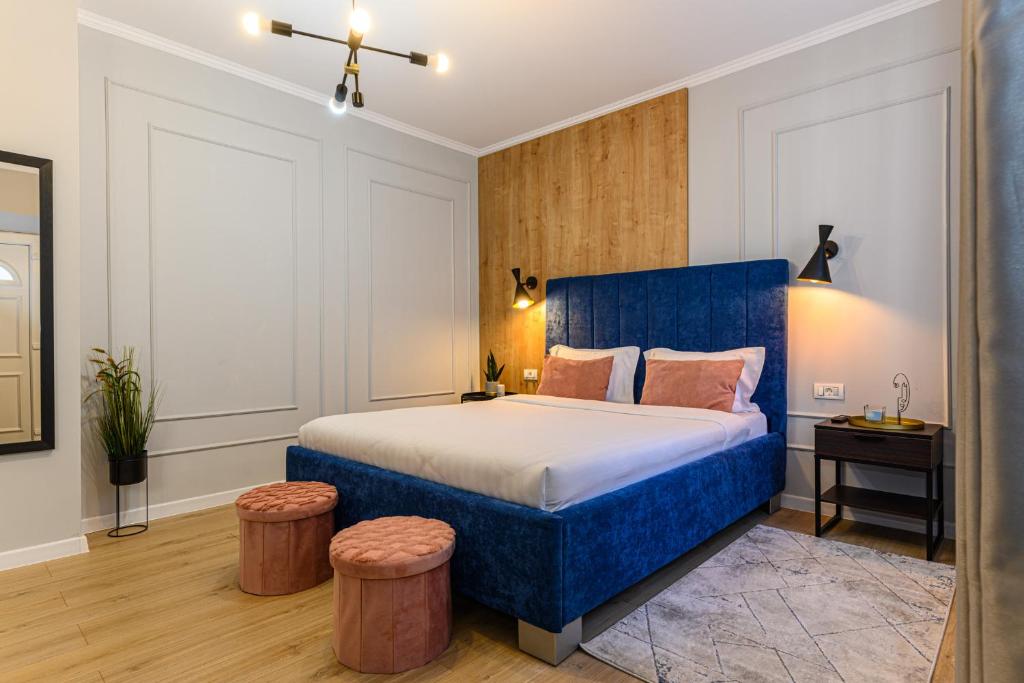 sypialnia z niebieskim łóżkiem i 2 stołkami w obiekcie All Season Studios w Braszowie