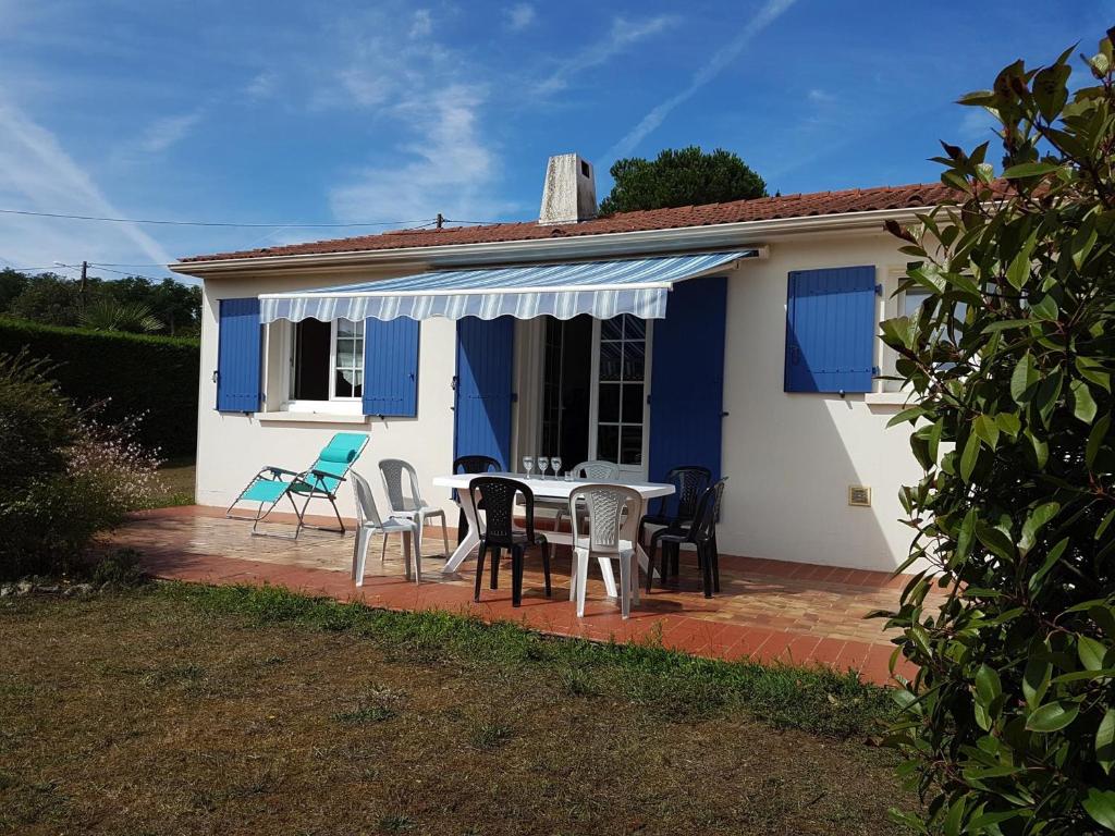 une maison avec une table et des chaises sur une terrasse dans l'établissement Maison Longeville-sur-Mer, 4 pièces, 6 personnes - FR-1-336-99, à Longeville-sur-Mer