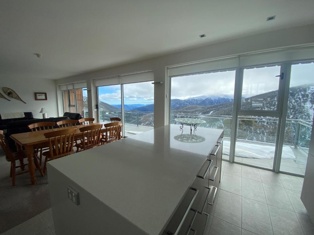 a kitchen and dining room with a view of the mountains at Woodsmoke Two Falls Creek in Falls Creek