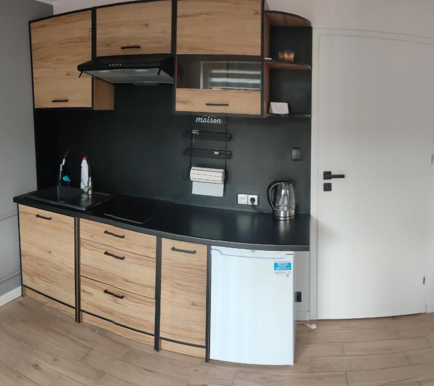 a kitchen with wooden cabinets and a white refrigerator at Trzy kolory in Bielsko-Biała