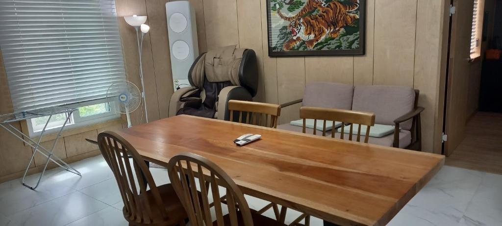 濟州的住宿－Hamdeok pool villa pension，一间带木桌和椅子的用餐室