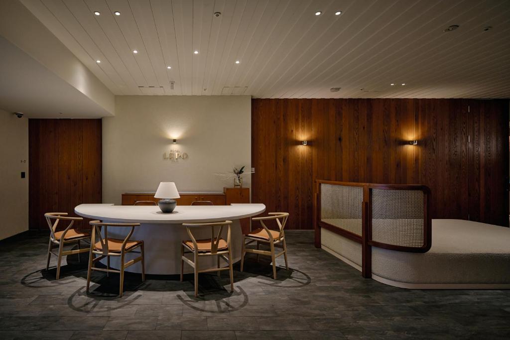 een kamer met een tafel en stoelen en een bed bij Hotel Lepo Chahal in Matsuyama