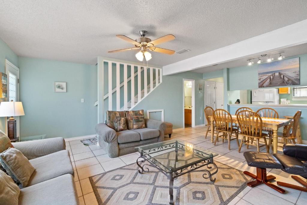 a living room with a ceiling fan and a table at Sugar Beach D17 in Navarre
