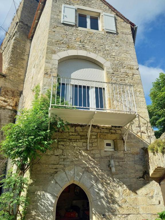 un bâtiment avec un balcon au-dessus dans l'établissement Maison du XVème au cœur du village médiéval, à Martel
