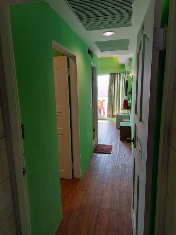 an empty hallway with green walls and wooden floors at 韖旅店-民宿編號1158 in Kenting