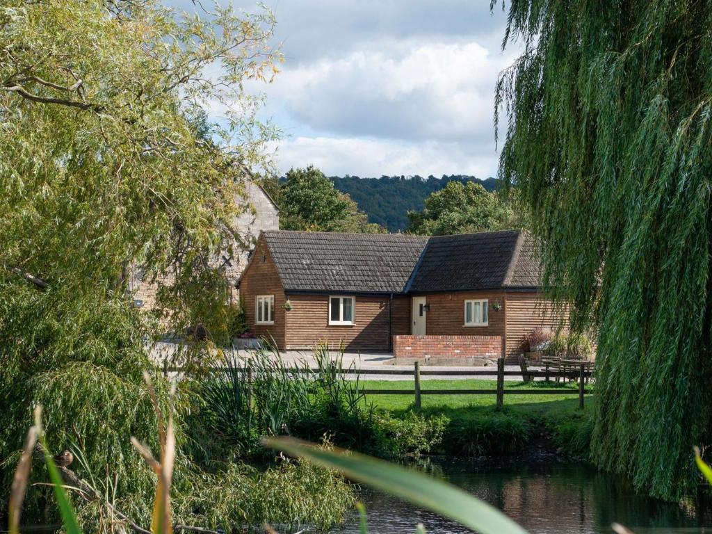 a house with a pond in front of it at Priory Barn in Frocester