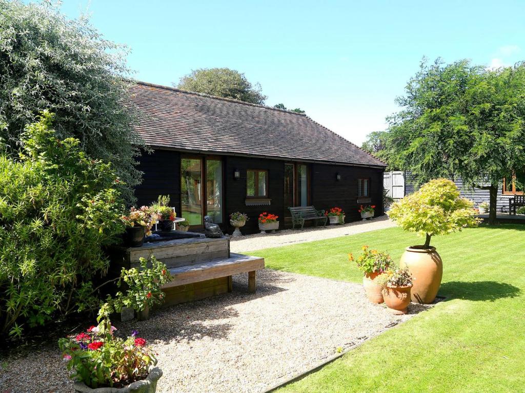 a house with a bench and potted plants in front of it at Ivy Cottage in Westfield