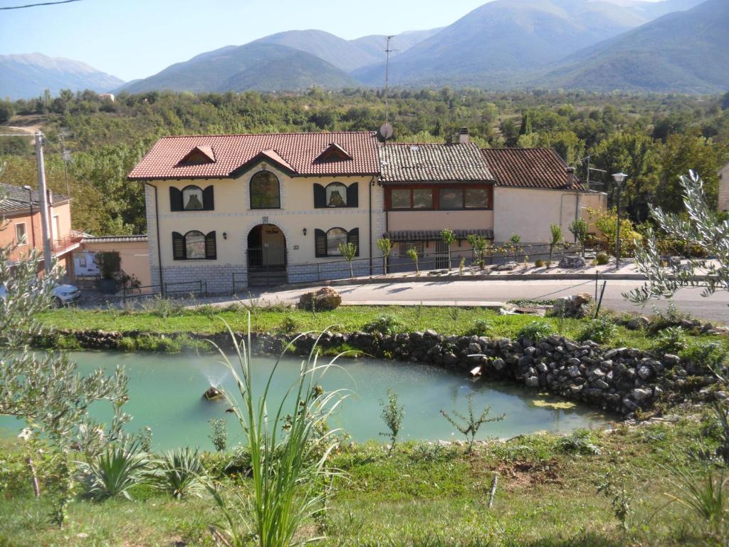 une maison avec un étang en face de celle-ci dans l'établissement Giamia Villas, à Sulmona