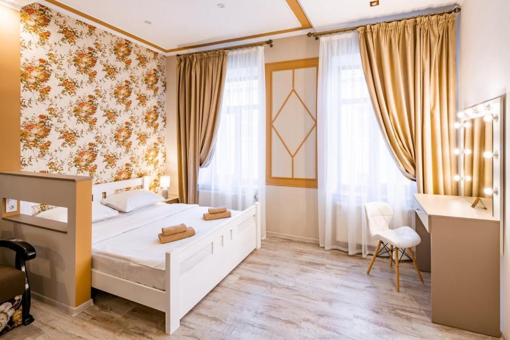 a bedroom with a bed and a desk and curtains at Apartment on Pekarska 15 in Lviv