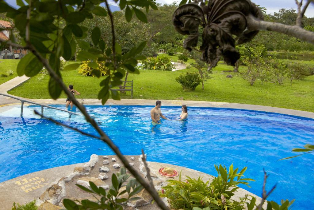 a group of people in a swimming pool at Hotel Colinas del Miravalles in Hacienda Guayabo